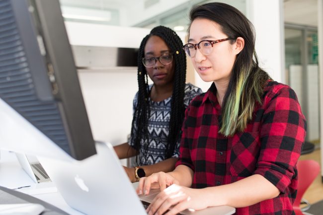 woman-wearing-red-and-black-checkered-blouse-using-macbook-1181472